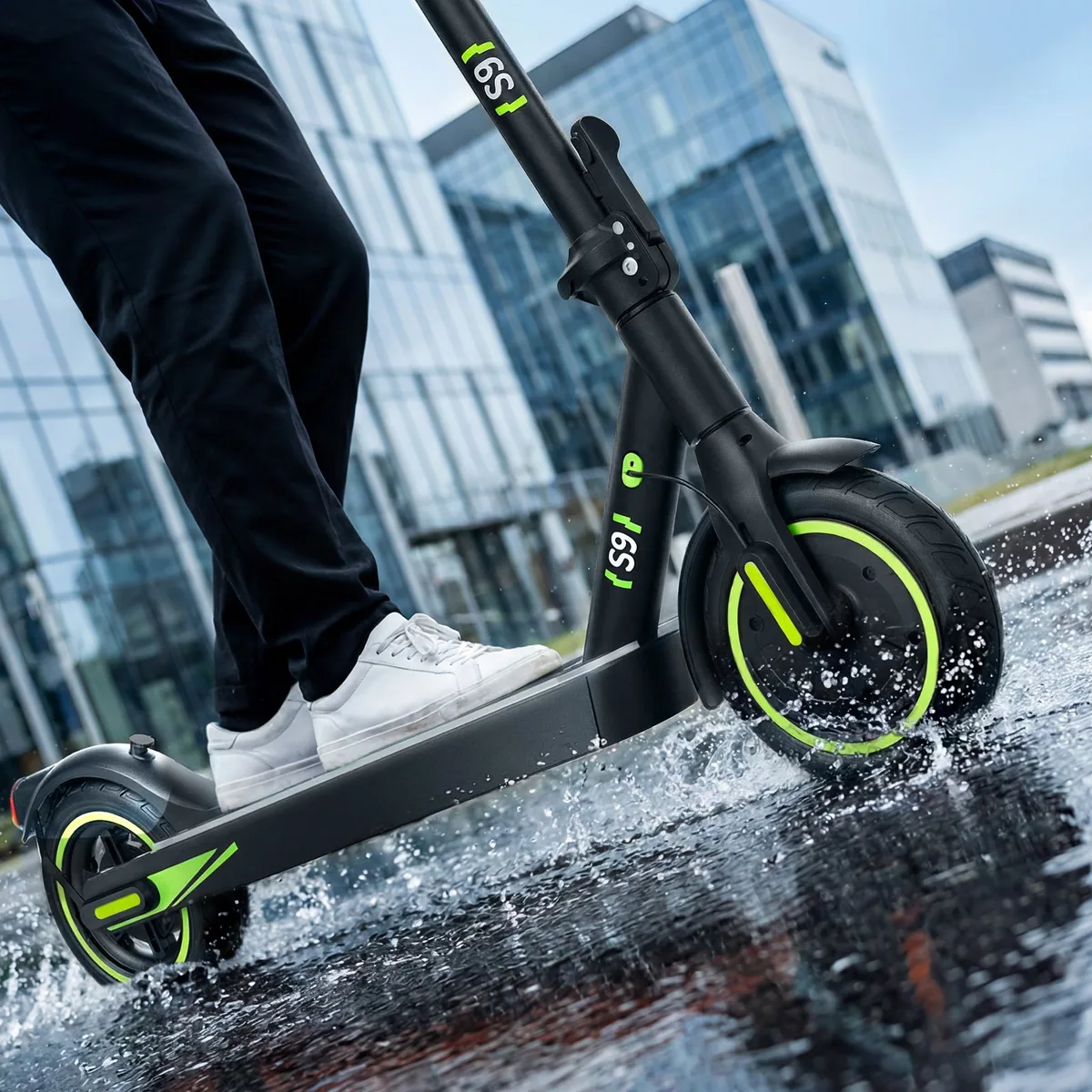 Trottinette électrique isinwheel S9 roulant sur un trottoir mouillé en ville, éclaboussures sous la roue