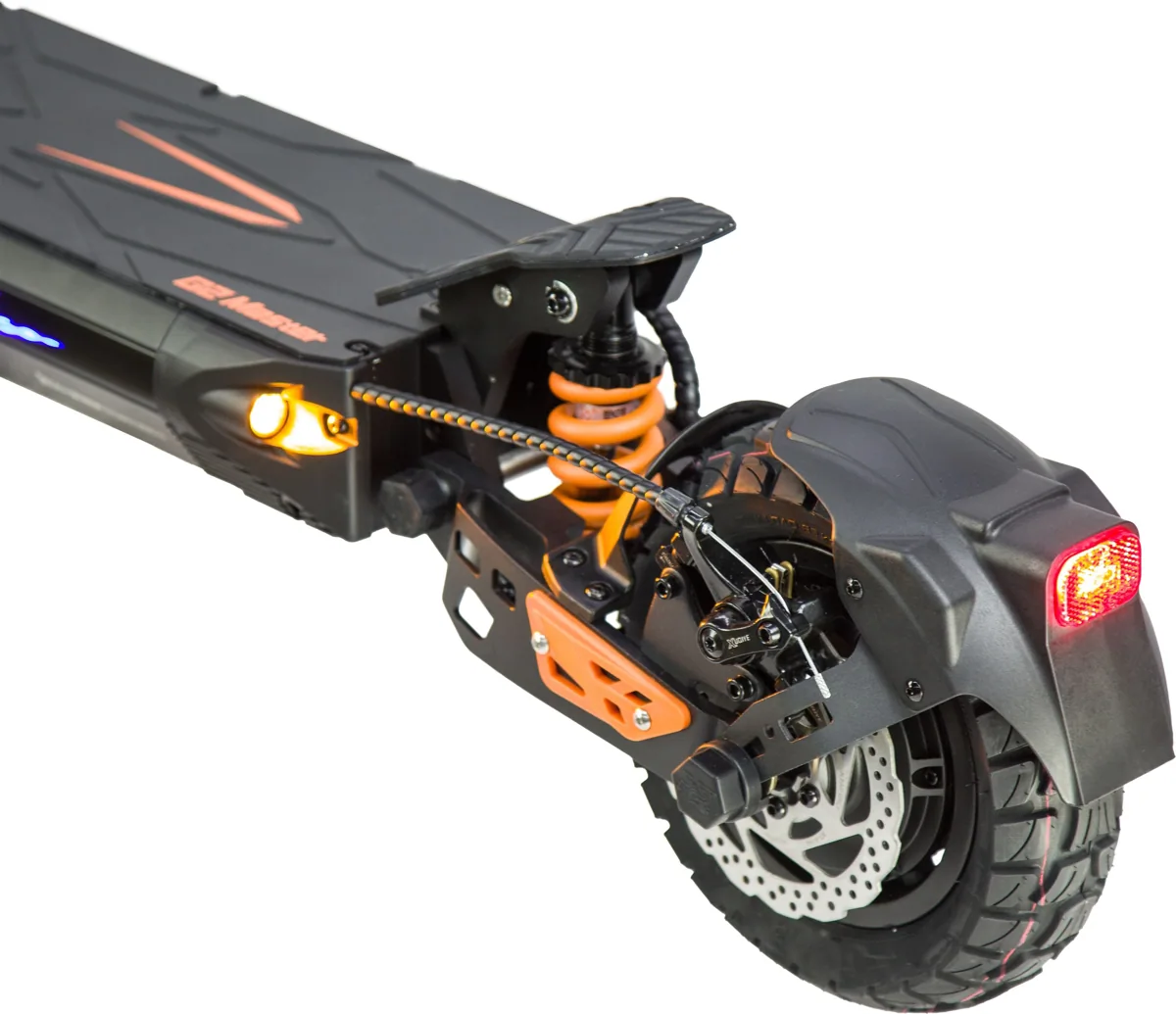 Gros plan sur l'arrière de la Kukirin G2 Master : amortisseur orange, frein à disque, pneu tout-terrain et feu rouge allumé