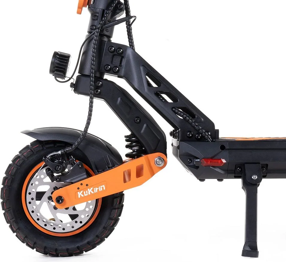 Gros plan sur la roue avant de la Kukirin G2 Max : frein à disque, bras oscillant orange et béquille