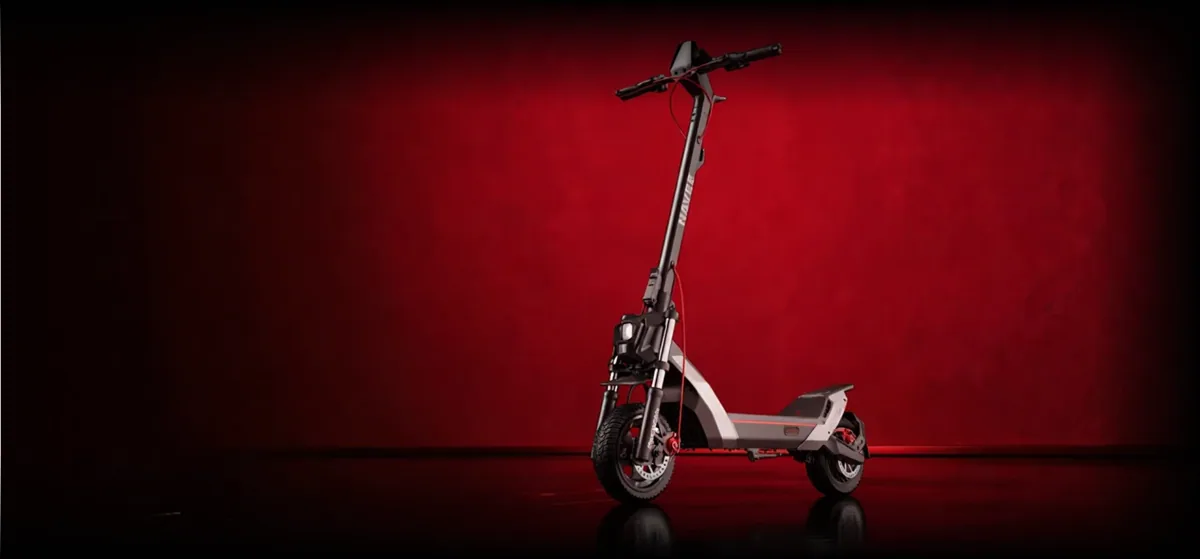 Trottinette électrique Navee NT5 Max posée de trois-quarts dans un studio éclairé en rouge