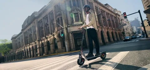 Homme roulant en Segway-Ninebot F3 Pro E au bord de l'eau, en noir et blanc