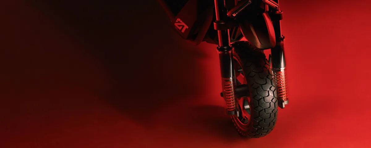 Roue avant et fourche à suspension de la Segway ZT3 Pro E sur fond rouge