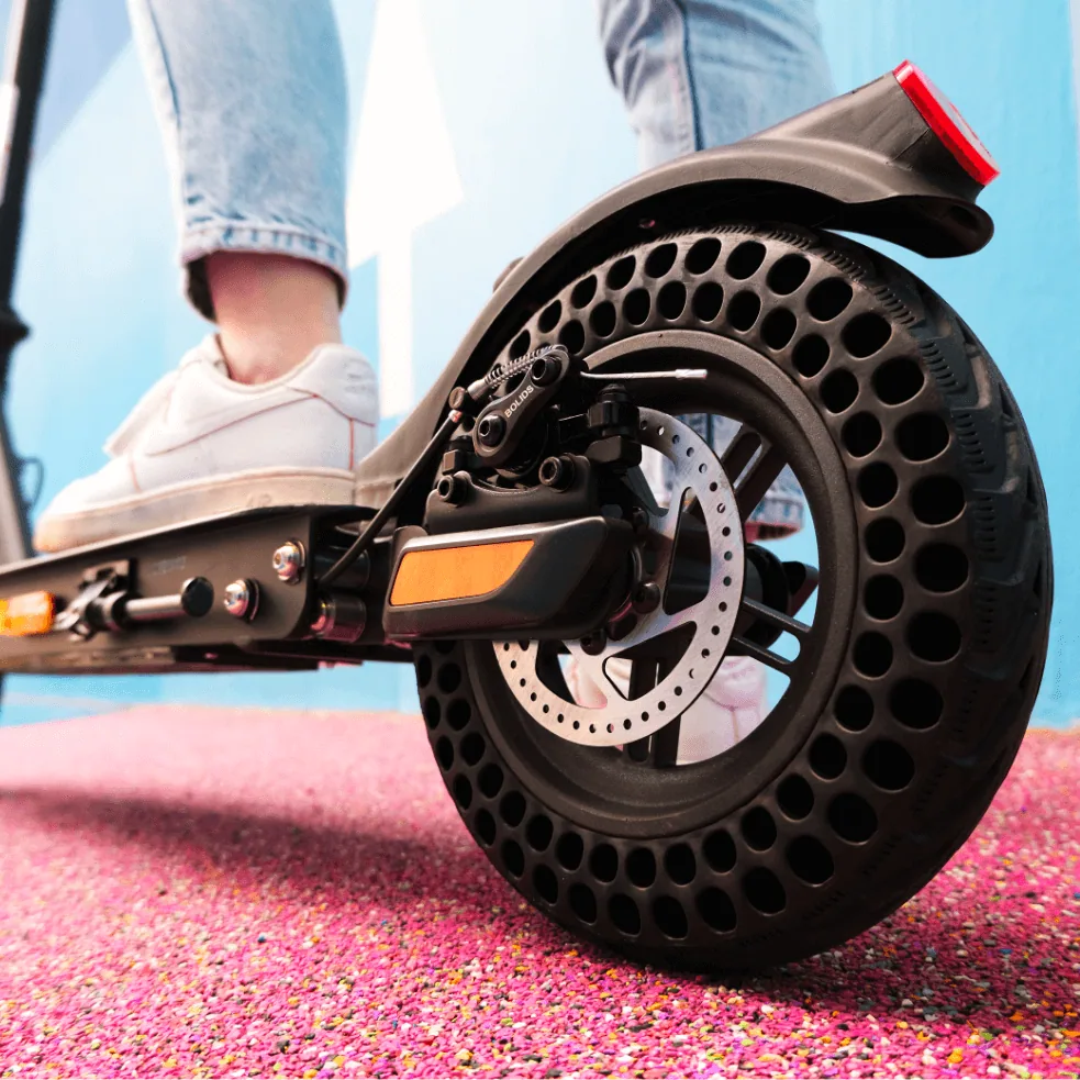 Gros plan sur la roue arrière alvéolée de l'Urbanglide Ride 100XS avec son frein à disque et son garde-boue