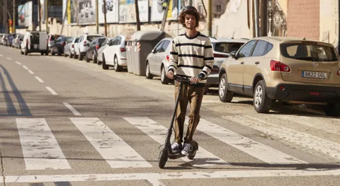 Homme roulant dans une rue sur la Mi Electric Scooter Essential