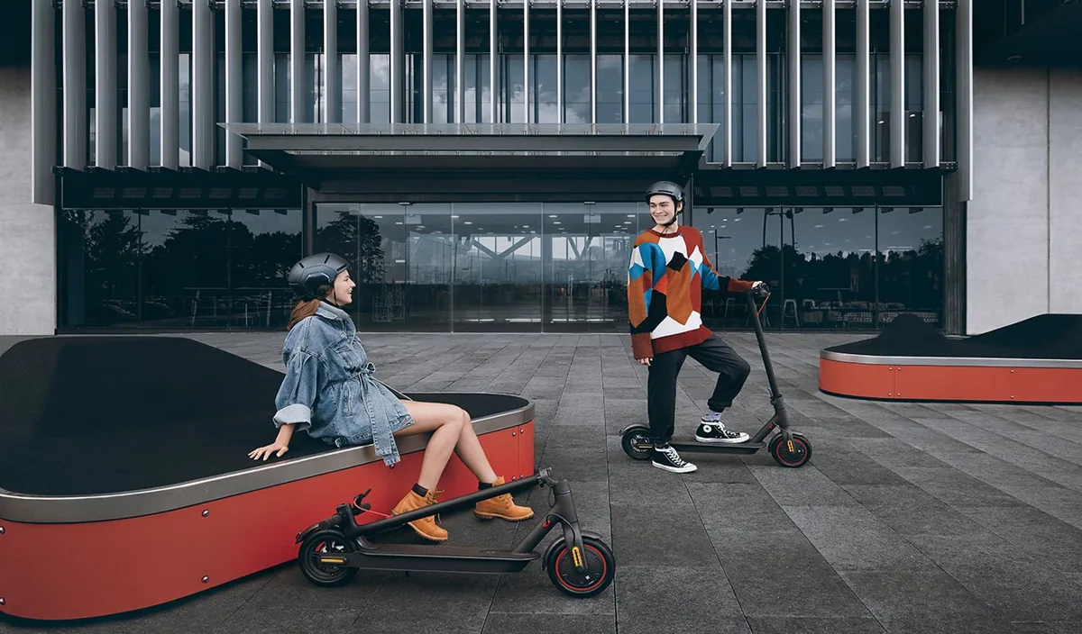 Deux personnes avec leurs Mi Electric Scooter Pro devant un bâtiment