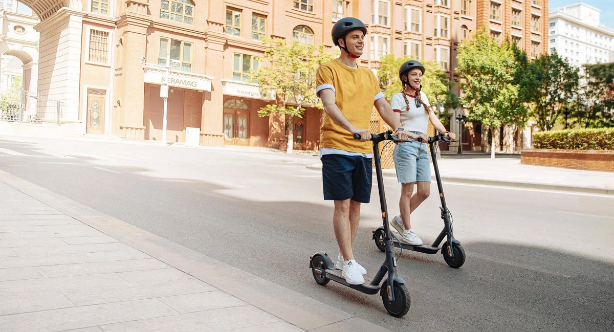 Deux personnes casquées roulant sur des Mi Electric Scooter 3 dans une rue