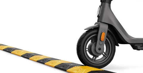 Roue avant de la Xiaomi Electric Scooter 4 Lite (2e génération) qui passe sur un ralentisseur jaune et noir