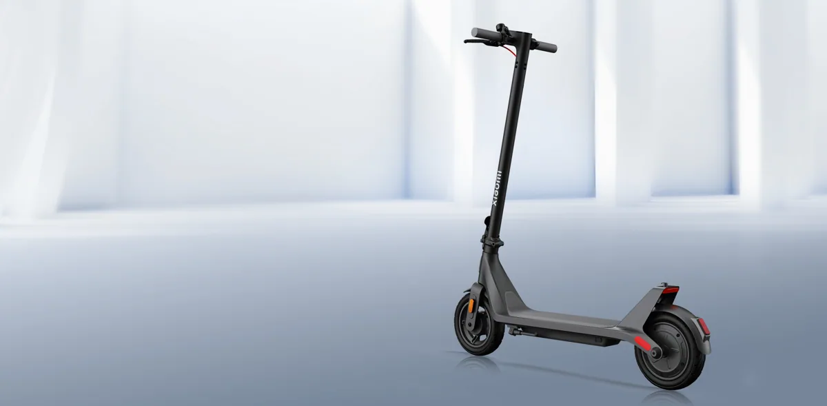 Trottinette électrique Xiaomi Electric Scooter 4 Lite (2e génération) grise, vue de trois quarts, dépliée, dans une pièce blanche