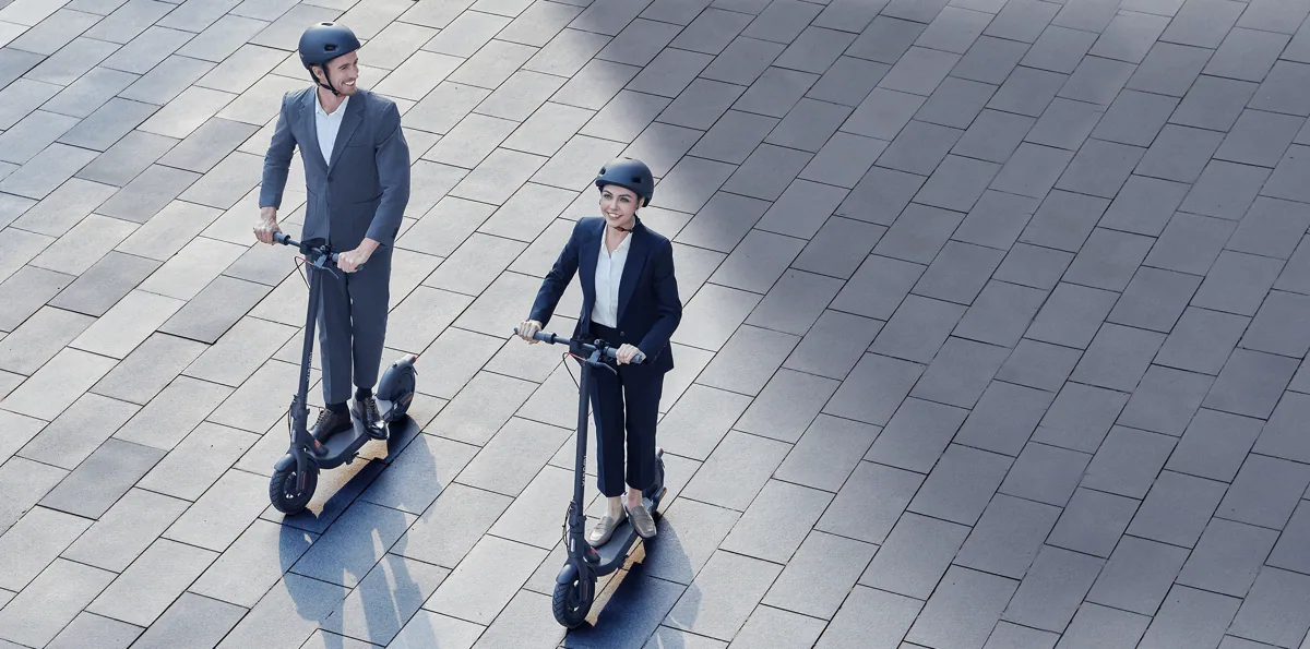 Deux personnes casquées sur des Xiaomi Electric Scooter 4 Pro (2e génération) sur un parvis, vue de dessus