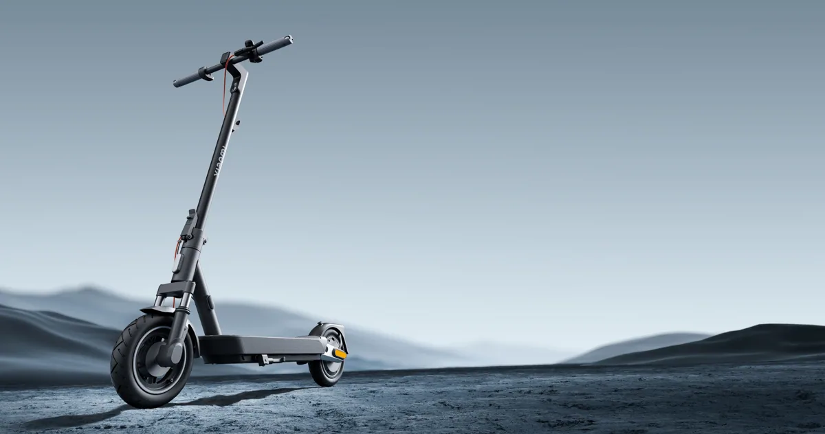 Trottinette électrique Xiaomi Electric Scooter 5 Pro noire, vue de trois quarts avant, dépliée, posée dans un paysage de montagne