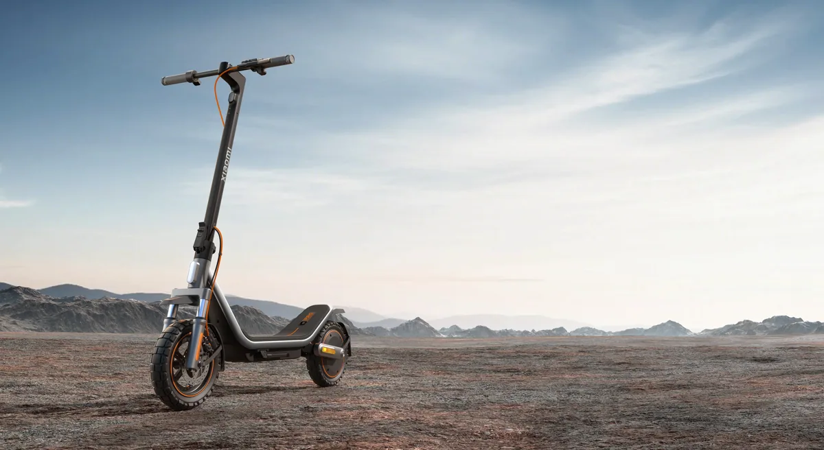 Trottinette électrique Xiaomi Electric Scooter 6 Pro noire, vue de trois quarts avant, dépliée, posée sur un sol de terre