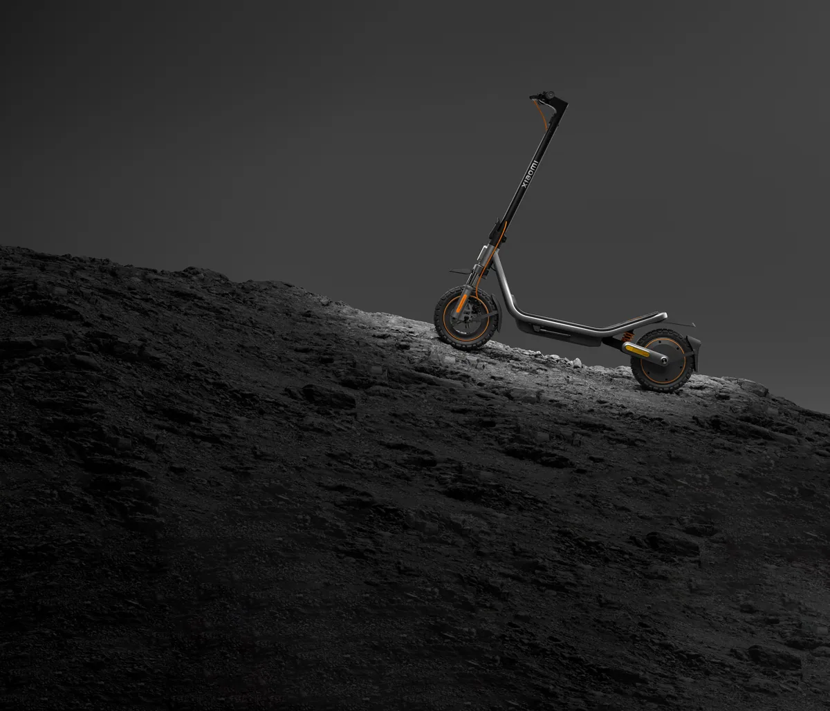 Trottinette électrique Xiaomi Electric Scooter 6 Pro noire posée sur un talus de terre sombre, vue de trois quarts