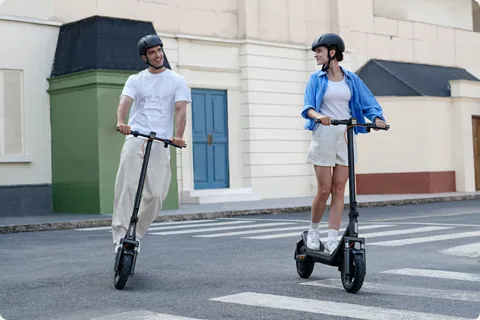 Deux personnes casquées qui roulent en Xiaomi Electric Scooter 6 en ville